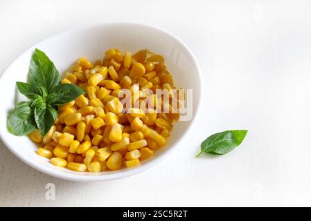 Delicious canned corn in white bowl isolated on white background. Healthy and vegetarian food. Copy space. Stock Photo