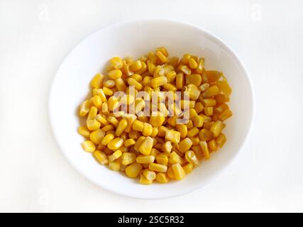 Delicious canned corn in white bowl isolated on white background. Healthy and vegetarian food. Copy space. Stock Photo