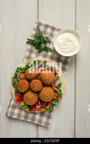 Tortillas, wrapped falafel balls, with fresh vegetables, vegetarian healthy food, on a wooden white background, no people, selective focus Stock Photo