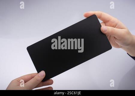 Rectangular shaped black notice board in hand on white background Stock Photo
