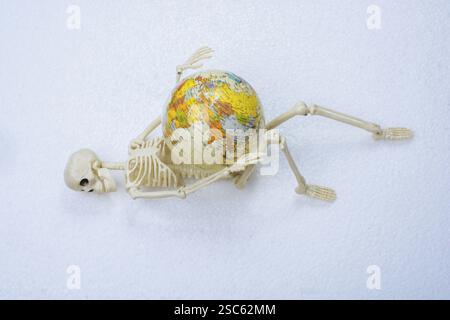 Artificial human body skeleton holding a model globe Stock Photo