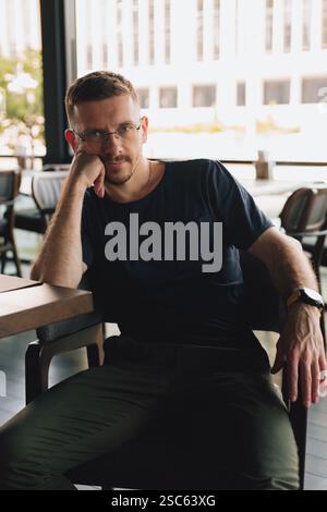 A young guy sits relaxed in a cafe Stock Photo