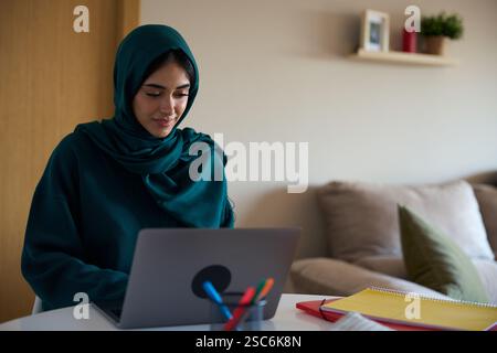 Young muslim woman working from home on laptop Stock Photo