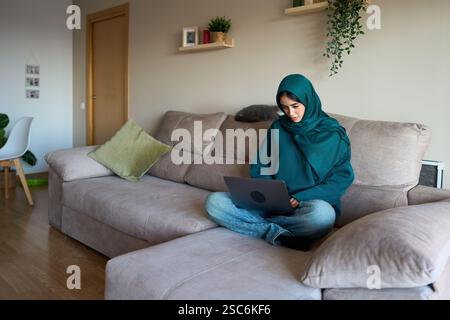 Young muslim woman working from home on laptop Stock Photo