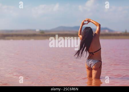Woman enjoying nature in pink lake Stock Photo