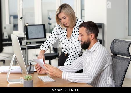 Technicians making digital engineering drawing on computer at desk in office Stock Photo