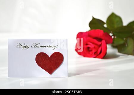 Happy Anniversary card with one red and yellow rose sprinkled with ...