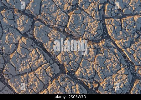 old patterned ground background texture from desert mudcracks with sand in the cracks Stock Photo