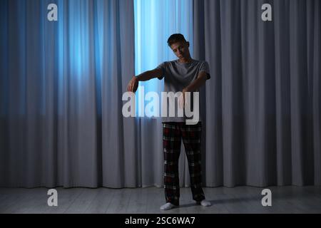 Young man suffering from sleepwalking at home Stock Photo