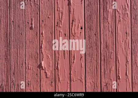 old flaking and peeling red painted vertical wood board wall background Stock Photo