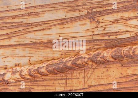 scraped and scratched rusted brown painted metal background with weld line across it Stock Photo