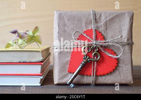 Valentines Day gift box wrapped in recycled brown paper and decorated with red heart and vintage key Stock Photo