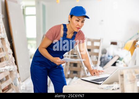Female engineer using laptop during repair works Stock Photo