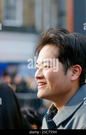 Close-up of a smiling asian man with short hair in an outdoor urban setting at chinese new year parade newcastle upon tyne uk Stock Photo