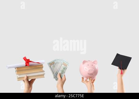 Female hands with money, diploma, piggy bank and graduation hat on light background Stock Photo
