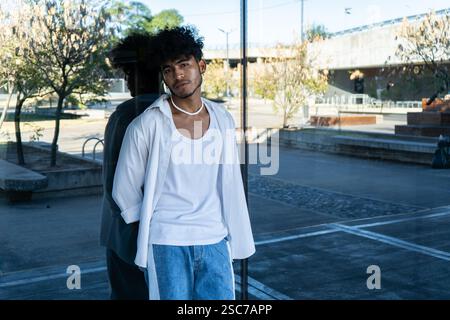 A Young Latino man resting leaning on a glass. Stock Photo