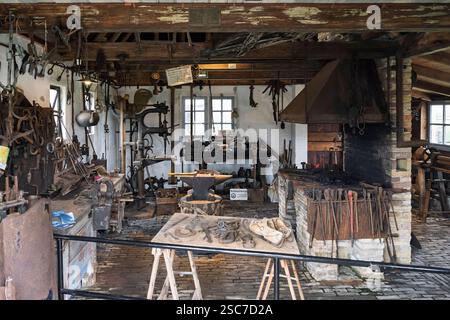 A vintage blacksmith workshop with tools, an anvil, and a forge. Stock Photo