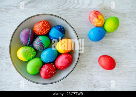 Colorful Easter eggs hand-painted at home. Using food coloring to dye Easter eggs. Painting eggs with candle wax. Getting ready for Easter egg hunt. F Stock Photo