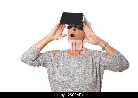 Elderly woman amazed while using a vr headset Stock Photo