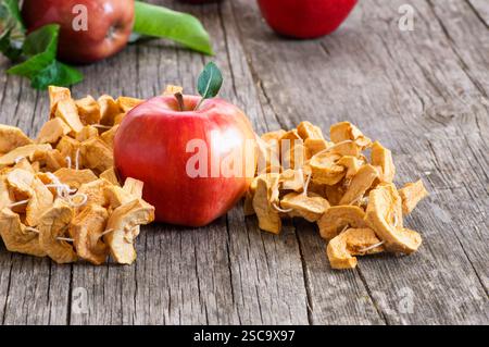 Dried sliced apple fruit with ripe fresh red apples on wooden rustic background, homemade dry fruit concept Stock Photo