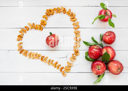 Dried sliced apple fruit with ripe fresh red apples on wooden rustic background, homemade dry fruit concept Stock Photo