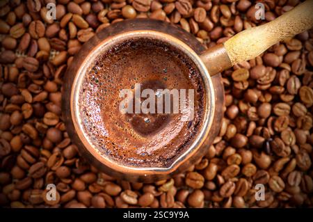 traditional turkish coffee in copper coffee pot with coffee beans on burlap sack, hot drink concept Stock Photo