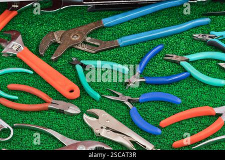 Assorted pliers wrench clamping tools displayed in open toolbox drawer. Stock Photo