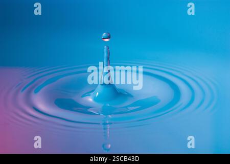 Water drop falling into water making a perfect concentric circles Stock Photo