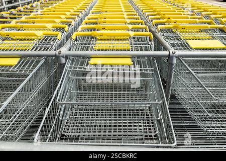Rows of yellow shopping carts in a rack. Stock Photo