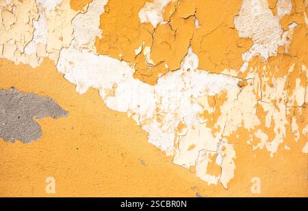 Yellow concrete wall with natural defects: faults, cracks, chips, scratches, crevasses, roughness. Could be used as background for design. Stock Photo