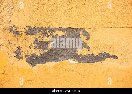 Yellow concrete wall with natural defects: faults, cracks, chips, scratches, crevasses, roughness. Could be used as background for design. Stock Photo