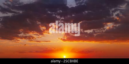 Panoramic view of a beautiful sunset with colorful clouds, capturing the dramatic interplay of light and sky. Stock Photo
