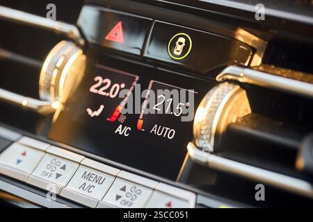 Automotive detailing climate control display dashboard with mode buttons close up. Luxury contemporary car interior detail selective focus shot. Stock Photo