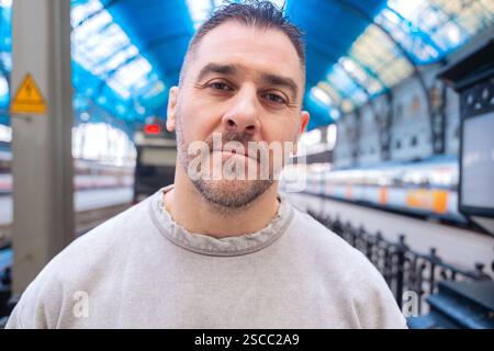 Thoughtful Man Looking Up at Train Station looking at camera Stock Photo
