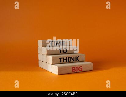 Time to think big symbol. Wooden blocks with words Time to think big. Beautiful orange background. Business and Time to think big concept. Copy space. Stock Photo