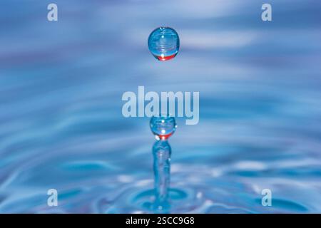 Water drop falling into water making a perfect concentric circles Stock Photo