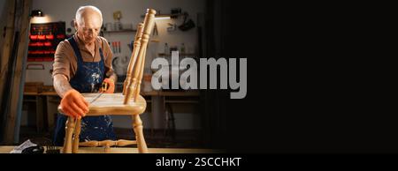 Senior carpenter measure old wooden chair with measurement tape in dark carpentry workshop. Furniture restoration, DIY and hobby concept Stock Photo