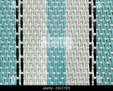 Close up of blue and white synthetic rattan or wicker weaving art in vertical stripes pattern. Rattan hand woven background seamless texture. Stock Photo