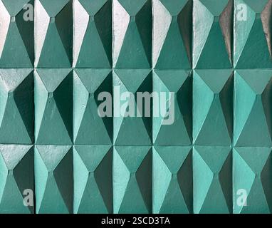 3D carved pyramidal and triangular 3D tiles in green tosca paint finish. 3D pyramid tiles for wall panel finishes, seamless background texture Stock Photo