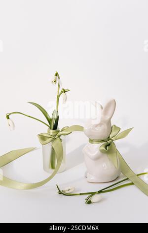 Spring, Easter composition with bunny and spring flowers. In a small vase there are snowdrops and an Easter bunny on a white background. Stock Photo