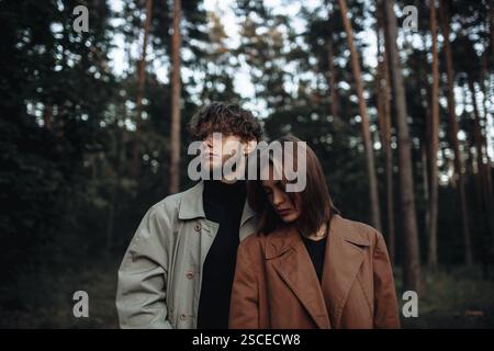A couple leaning on each other in a calm forest ambiance Stock Photo