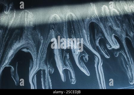 Abstract texture with white watery patterns over a dark surface Stock Photo