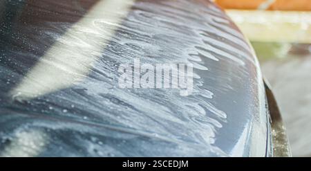 Close-up of car hood with water and soap marks during wash Stock Photo