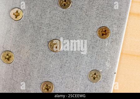 fixed one silver corner with a lot of holes for connecting wooden parts with screws, metal building products closeup Stock Photo