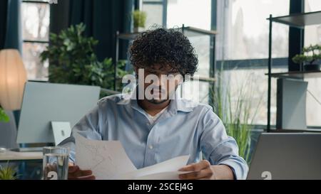 Focused businessman business person accountant office worker writing ideas in notebook paperwork Arabian Indian student write notes data information e Stock Photo