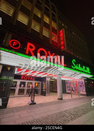 A retro neon sign glowing in red, green, and white on a historic cinema in Malm?, Sweden, casting a nostalgic glow on a cold, lonely street at night. Stock Photo