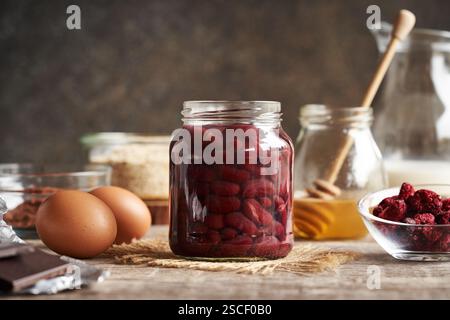 Ingredients for baking gluten-free brownies - red kidney beans in a jar, oat flakes, eggs, cocoa, honey and freeze-dried raspberries Stock Photo