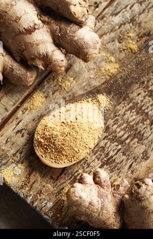 Ground ginger powder with fresh ginger root on a wooden table Stock Photo