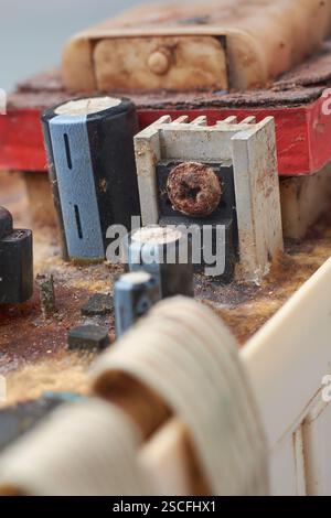 close-up of damaged or disassembled various components of circuit board of electronic device, corroded capacitors, IC and transformer, soft focus Stock Photo