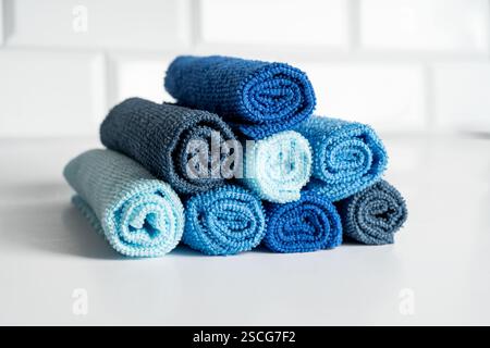 Colorful microfiber towels in the form of pyramid on a white table. Cleaning and housekeeping concept Stock Photo